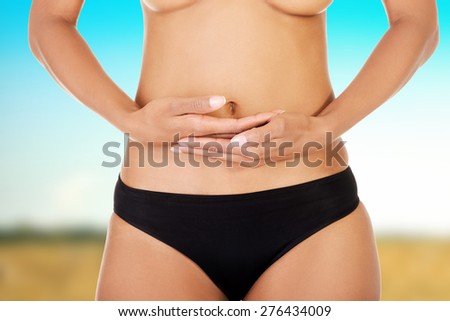 Beautiful and slim woman\'s belly with hands on it.
