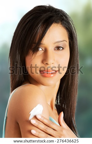 Beautiful spa woman with lotion on arm.