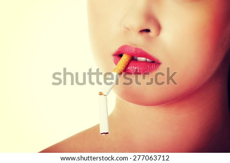 Young woman with broken cigarette in mouth.