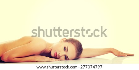 Sexy fit naked woman lying on belly.