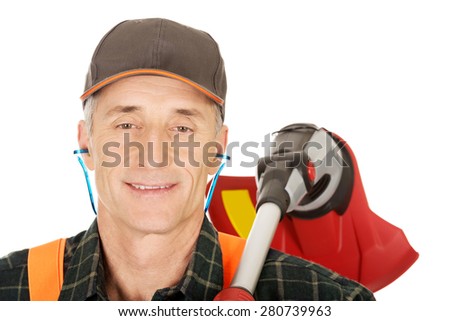 Experienced gardener with trimmer and ear protectors