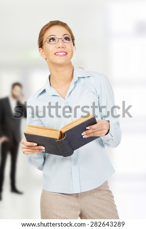Dreaming business woman holding a book.