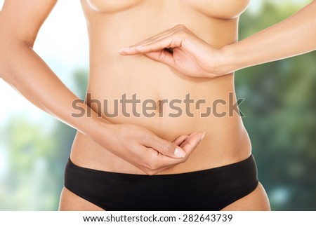 Beautiful and slim woman\'s belly with hands on it.