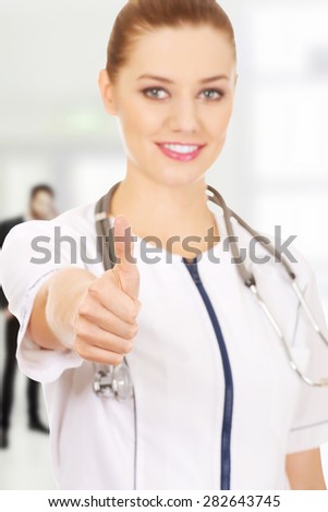 Smiling medical doctor woman with thumbs up.