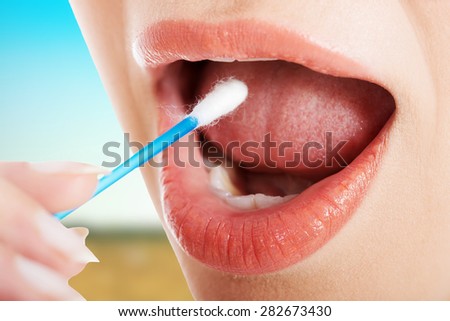 Young woman putting ear stick into mouth.