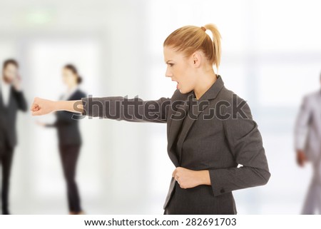 Angry businesswoman screaming and shaking her fist.