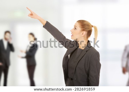 Shocked beautiful businesswoman pointing up.
