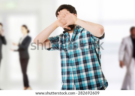 Young handsome afraid man covering his face.