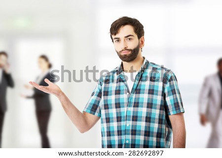 Young caucasian man showing something on palm.