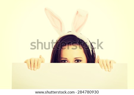 Happy woman wearing bunny ears and holding an empty baner