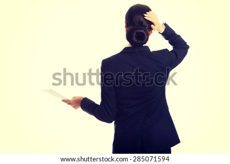 Tired businesswoman with paper notes touching her head.