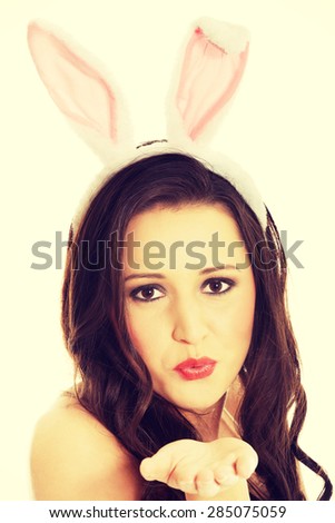 Woman wearing bunny ears and blowing a kiss.