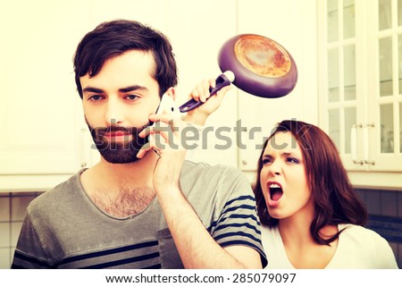 Young rage woman hitting her talking partner with frying pan.