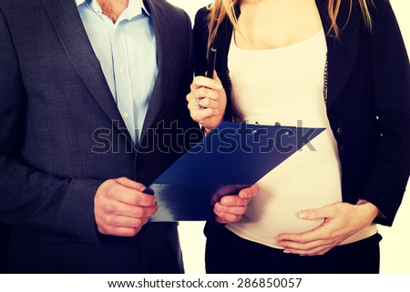 Working pregnant woman signing contract with her partner
