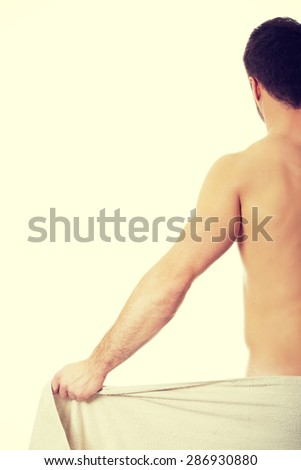 Topless muscular man wrapped in towel.
