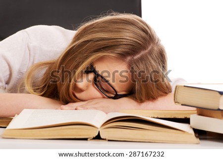 Exhausted teenage woman sleeping on the desk