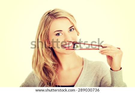 Happy woman eating tasty sushi