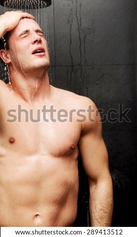 Handsome muscular man at the shower.