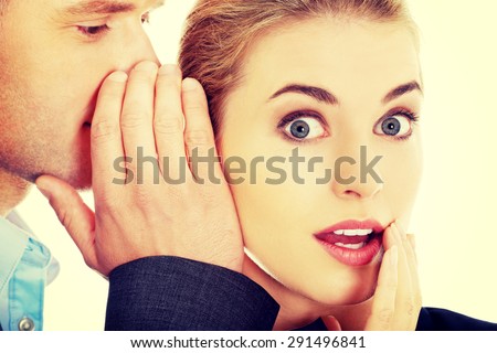 Men whispering secret to his surprised friend