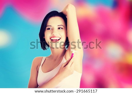 Young happy woman shaving armpit
