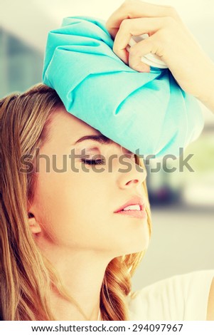 Beautiful woman with ice bag having headache.