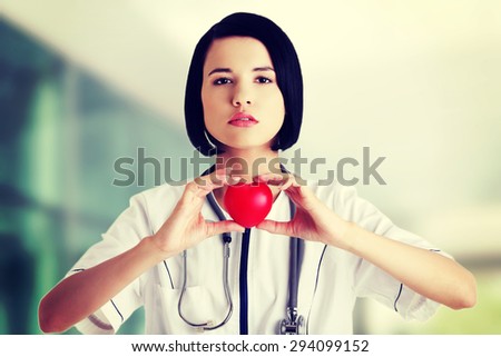 Young female doctor holding heart model