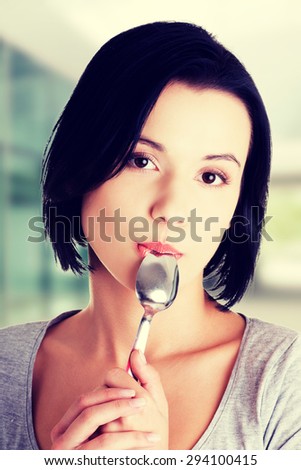Beautiful woman with spoon in her mouth