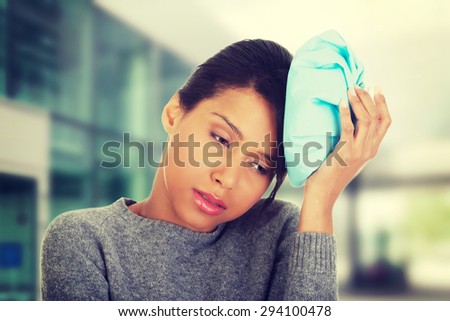 Woman with ice bag having headache.