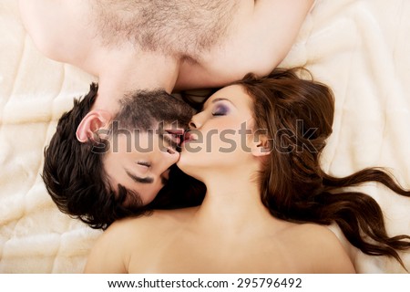 Relaxed loving young couple kissing in bed.