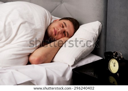 Handsome man sleeping in bed.