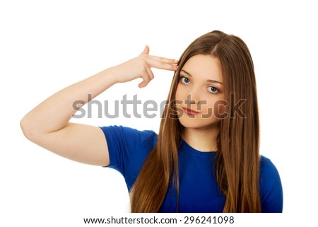 Young woman with hand to head in the shape of gun.