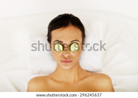 Woman in spa with cucumber on eyes.