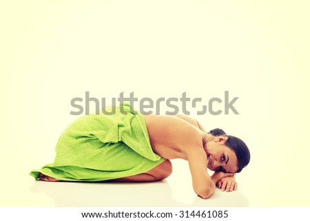 Spa woman curled up wrapped in towel