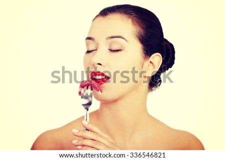 Young beautiful woman eating raw meat
