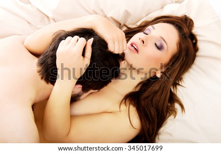 Young happy couple kissing on the bed.