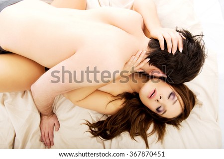Young lovers kissing on the bed.