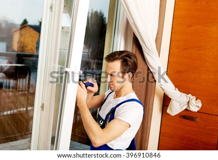 Young handyman repair window with screwdriver