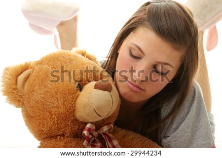 Beautiful teenager holding a teddy bear - isolated on white background