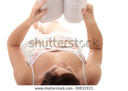 Pretty young girl in pyjamas with book in hands. Isolated over white background