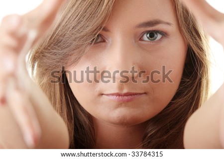 Beautiful young woman framing her face with her hands, isolated on white background