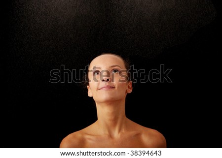 Close-up of beautiful happy wet woman face with water drop. Isolated on black background