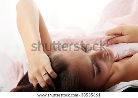Sensual young woman laying in pink bed. Sleeping