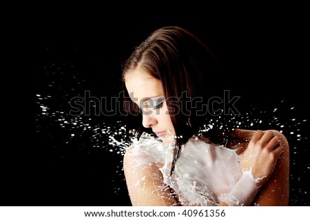 Young beautiful woman with milk, isolated on black. Skin care concept
