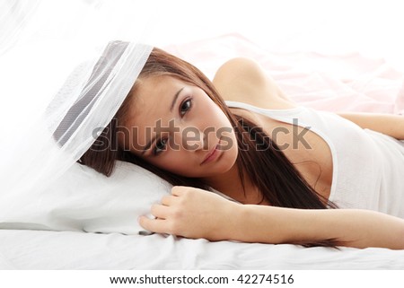 Sensual young woman laying in pink bed. Resting