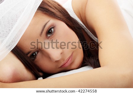 Sensual young woman laying in pink bed. Resting