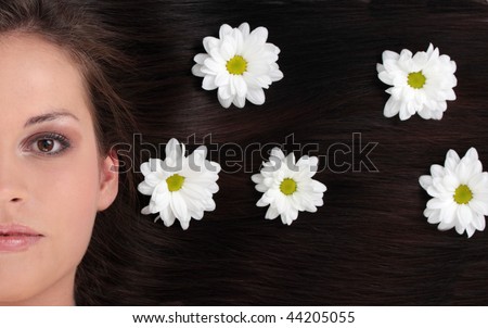 Close-up beautiful black-haired lady with white flowers in her hair