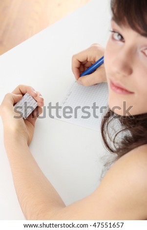 Young caucasian female student stands by school desk and  cheat