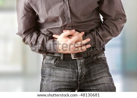 A man holding his stomach because he has diarrhea