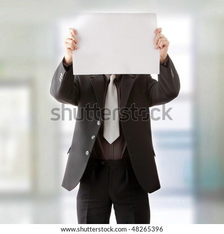 Young businessman holds blank signs. Focus on sign