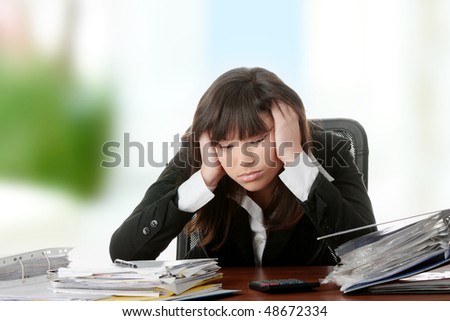 Female executive filling out tax forms while sitting at her desk.